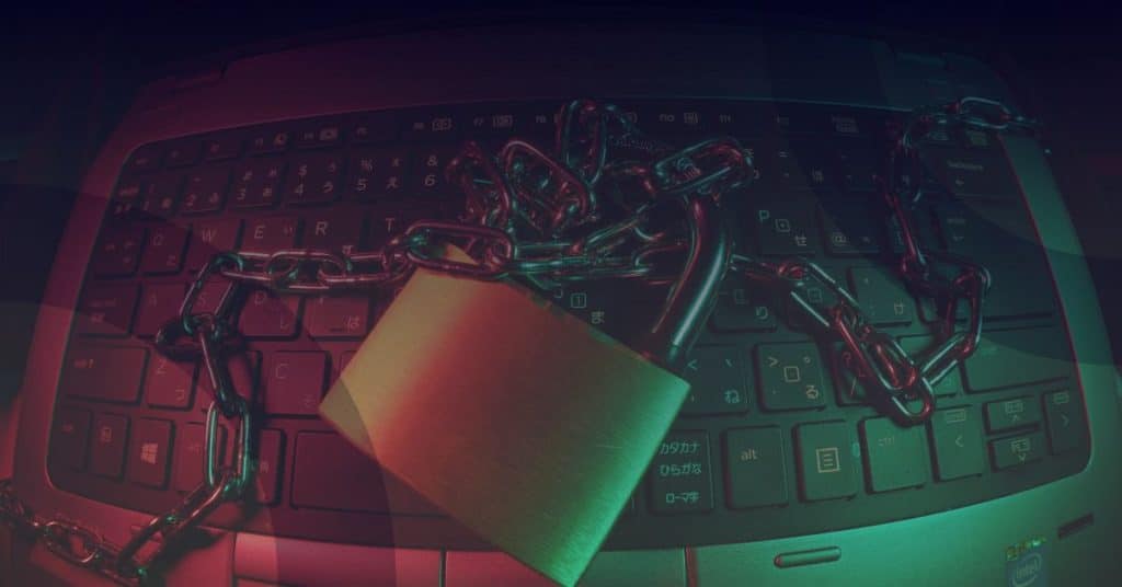 Padlock and chain on a laptop keyboard symbolizing cybersecurity and protection of digital assets.
