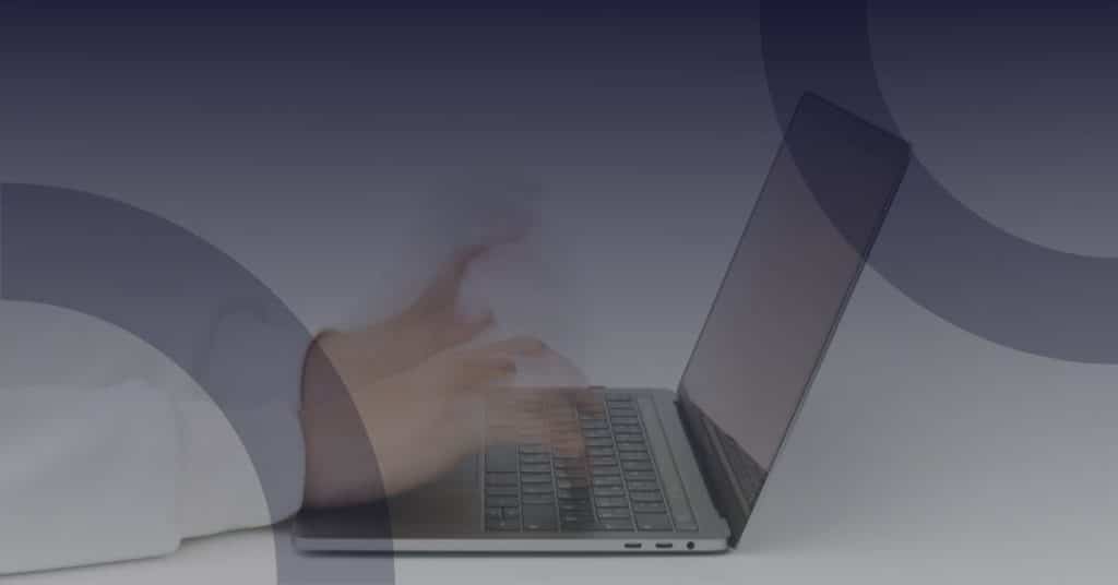 Person typing on a laptop, illustrating engagement in phishing simulation training for cybersecurity awareness.