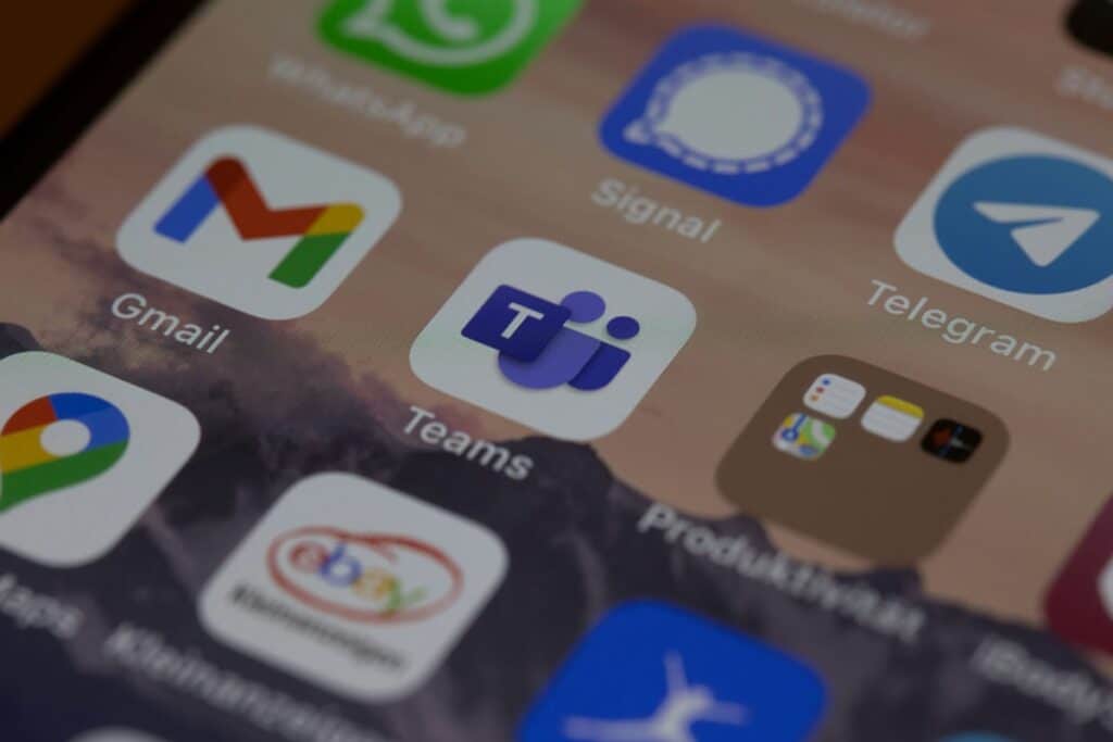 Mobile phone screen displaying Microsoft Teams app icon alongside other communication and productivity apps, emphasizing Microsoft 365 collaboration tools for remote work and business productivity.