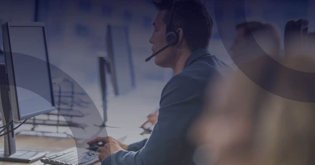 Person wearing a headset at a computer, representing industry-focused IT support and technology solutions for businesses.