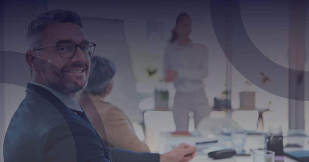 Business professionals in a meeting discussing IT readiness for private equity and M&A success.